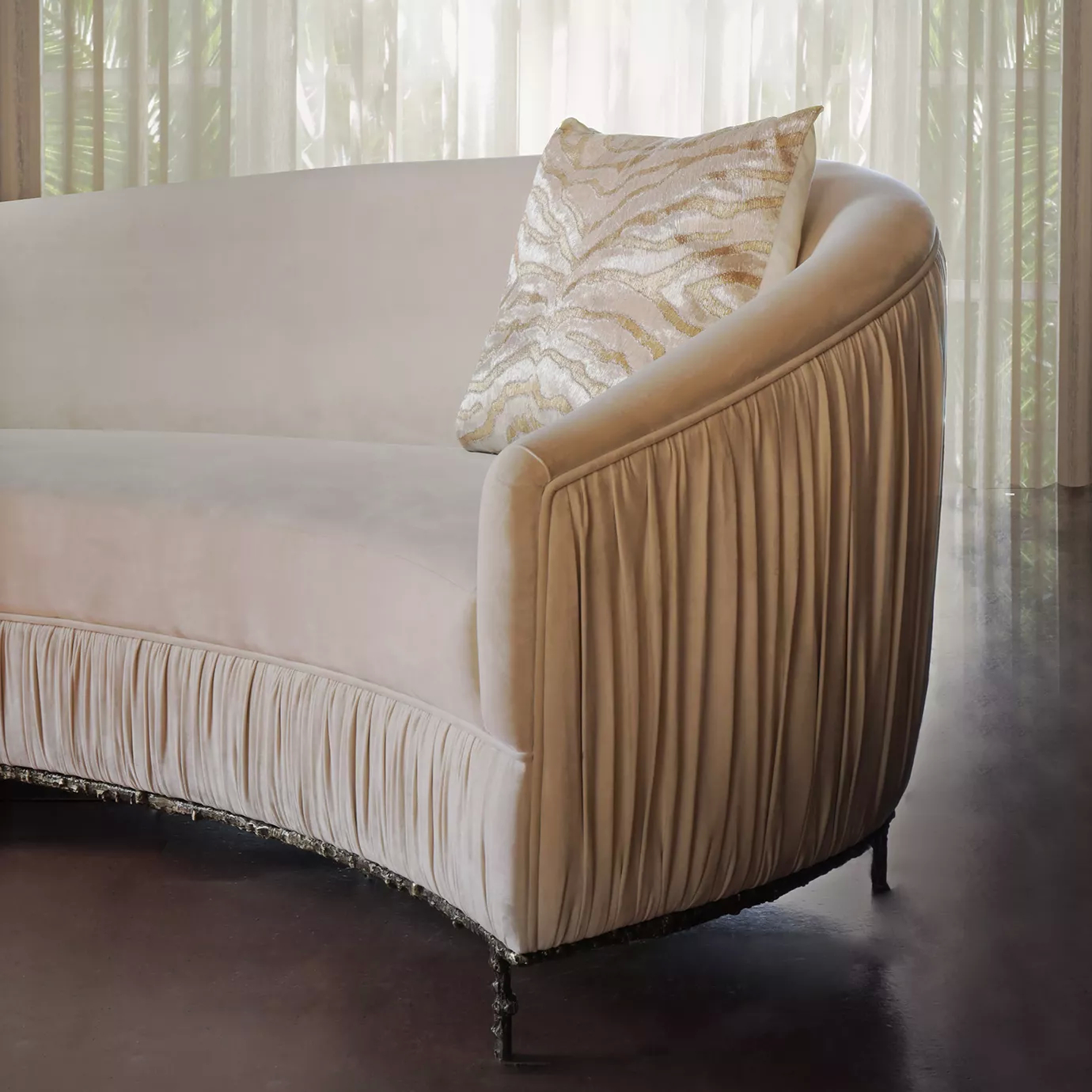 Elegant close-up of the Vamp Sofa with cream fabric upholstery with pleated details and a decorative cushion in a sophisticated setting.
