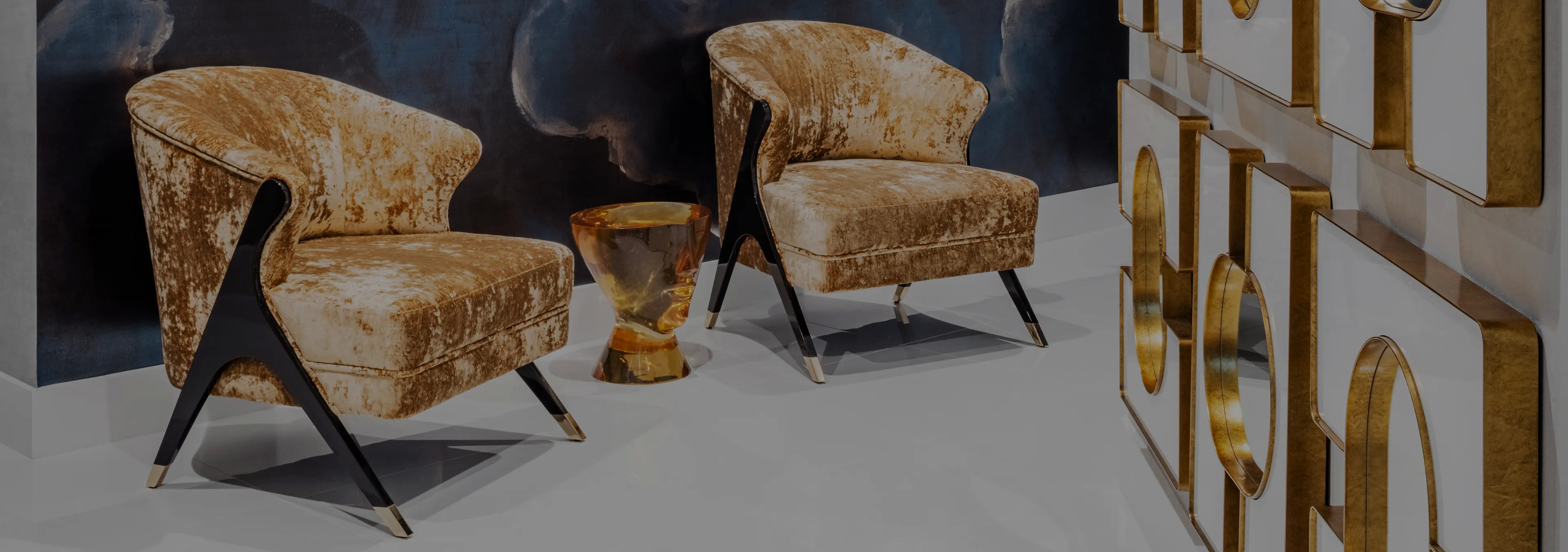 Labor of Love: Two Naomi chairs with golden velvet upholstery and black legs, with a decorative glass vase.