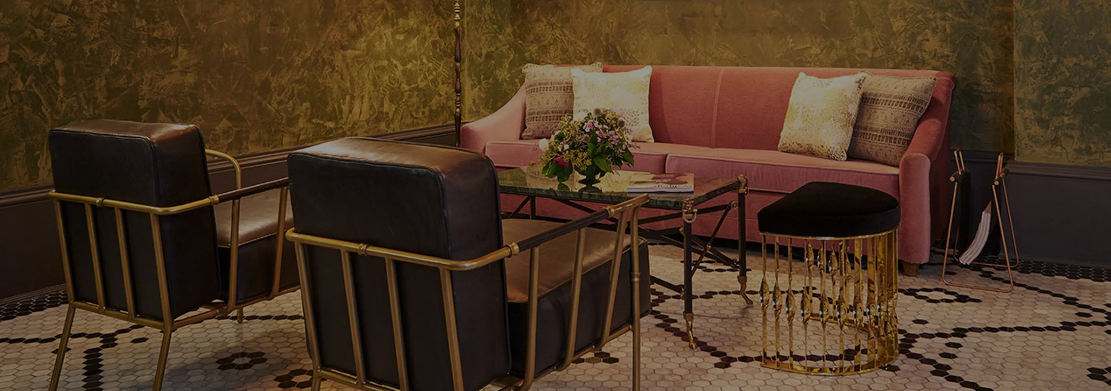 Labor of Love: Two Naomi chairs with golden velvet upholstery and black legs, with a decorative glass vase.