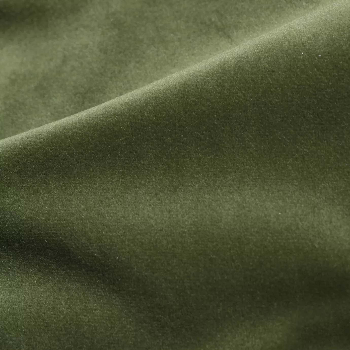 Elegant close-up of a Cozy Velvet Eden Green fabric swatch in a lush and deep eden green tone, showcasing its velvety texture and the gentle folds that give it a rich and inviting feel.