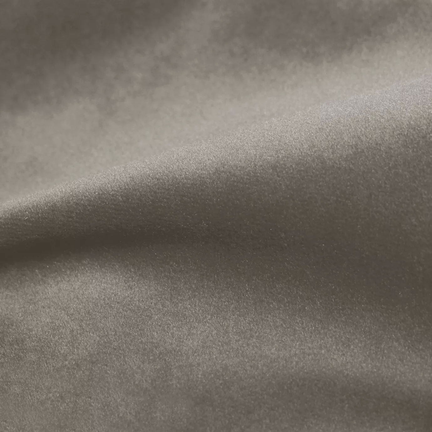Elegant close-up of a Cozy Velvet Greige fabric swatch in a soft and versatile grey-beige tone, showcasing its velvety texture and the gentle folds that highlight its subtle color depth.