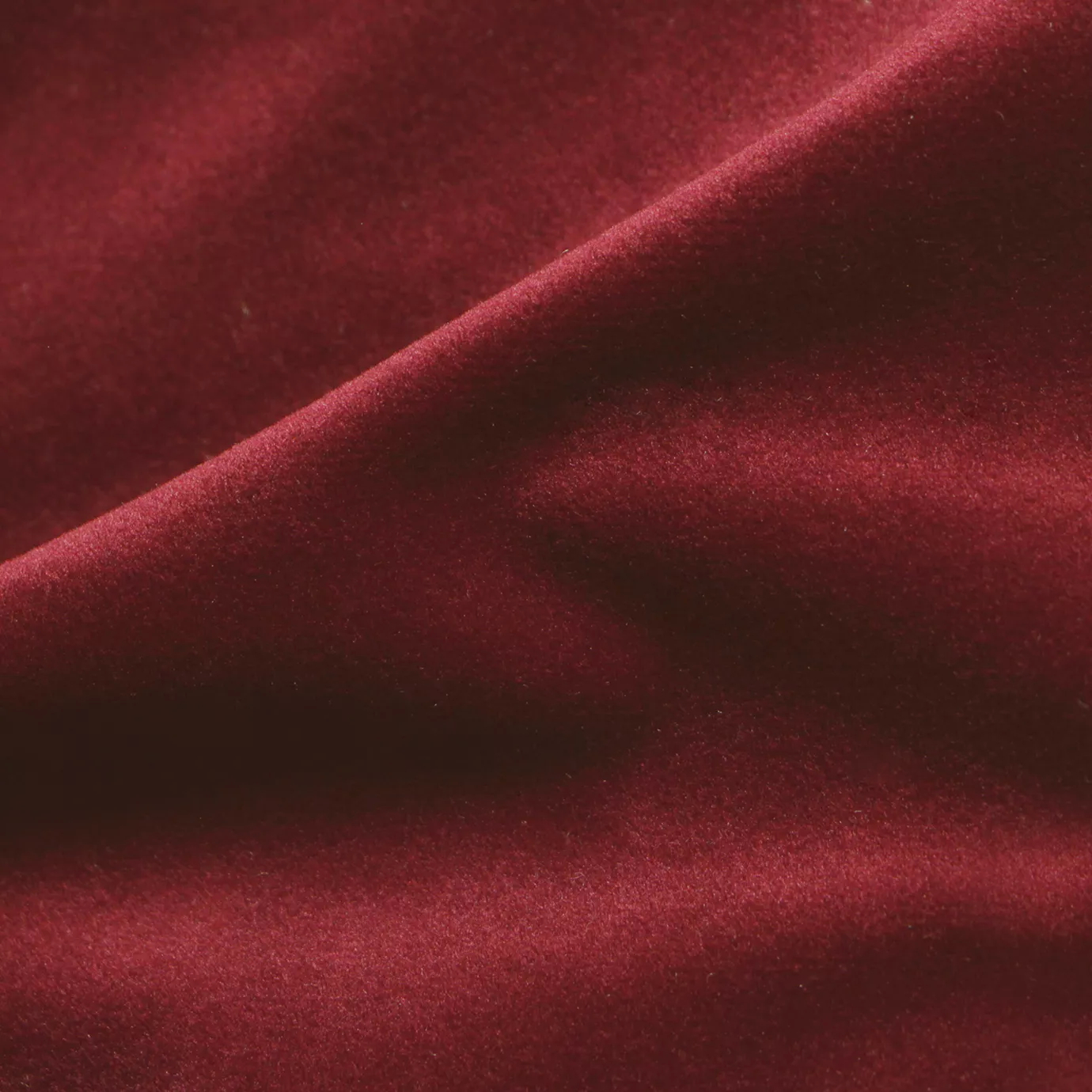 Elegant close-up of a Cozy Velvet Lipstick Red fabric swatch in a vivid and intense red tone, showcasing its velvety texture and the gentle folds that give it a rich sheen.
