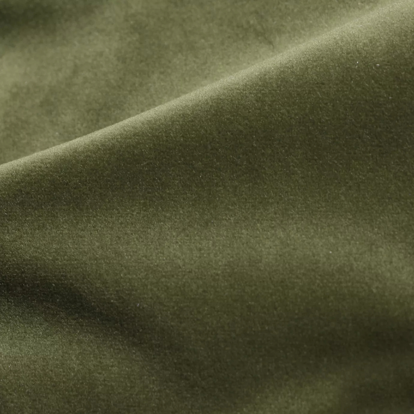 Elegant close-up of a Cozy Velvet Moss Green fabric swatch in a natural and soft moss green tone, showcasing its velvety texture and the gentle folds that give it an organic and inviting feel.