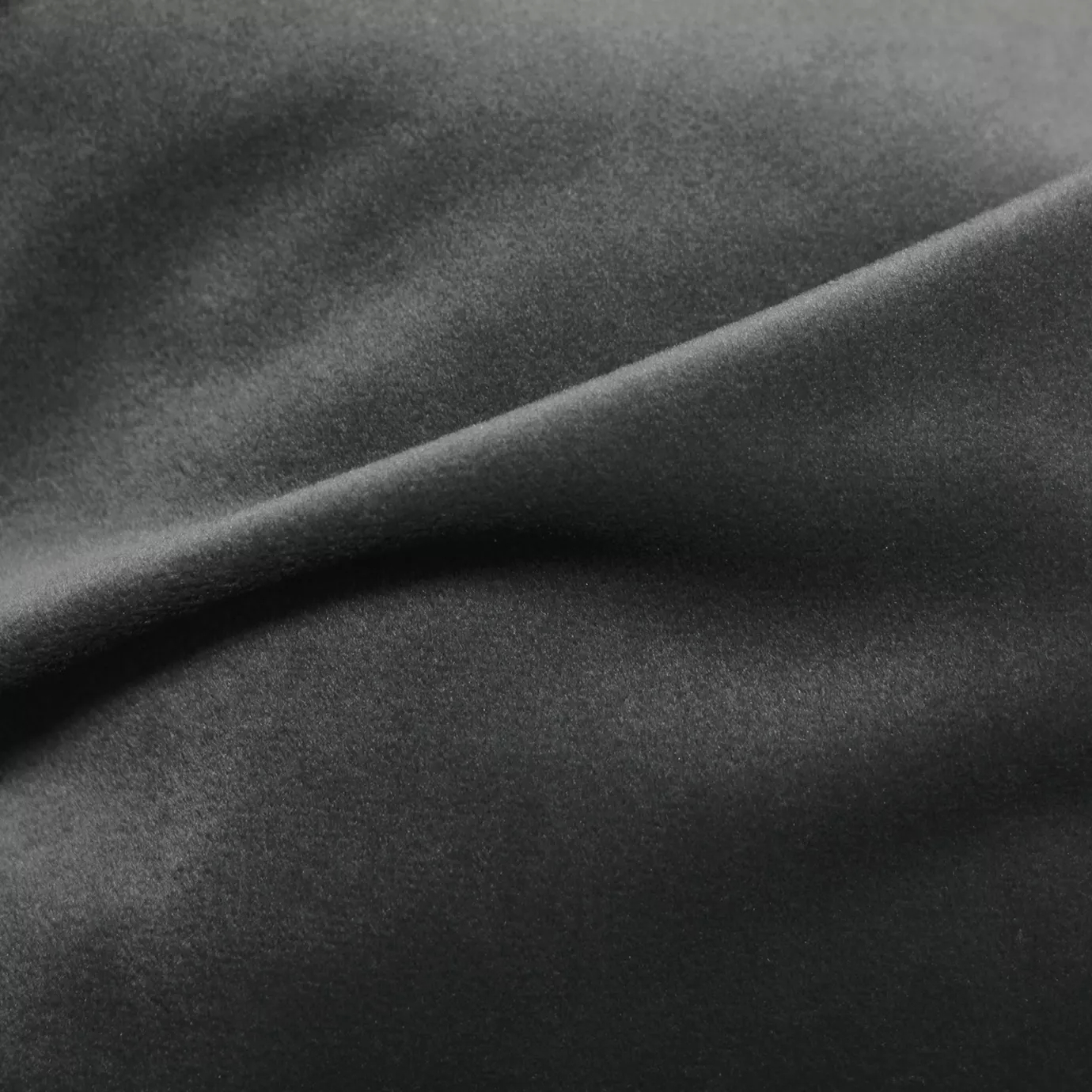 Elegant close-up of a Cozy Velvet Pavement Gray fabric swatch in a modern and neutral pavement gray tone, showcasing its velvety texture and the gentle folds that give it a feeling of urban comfort.