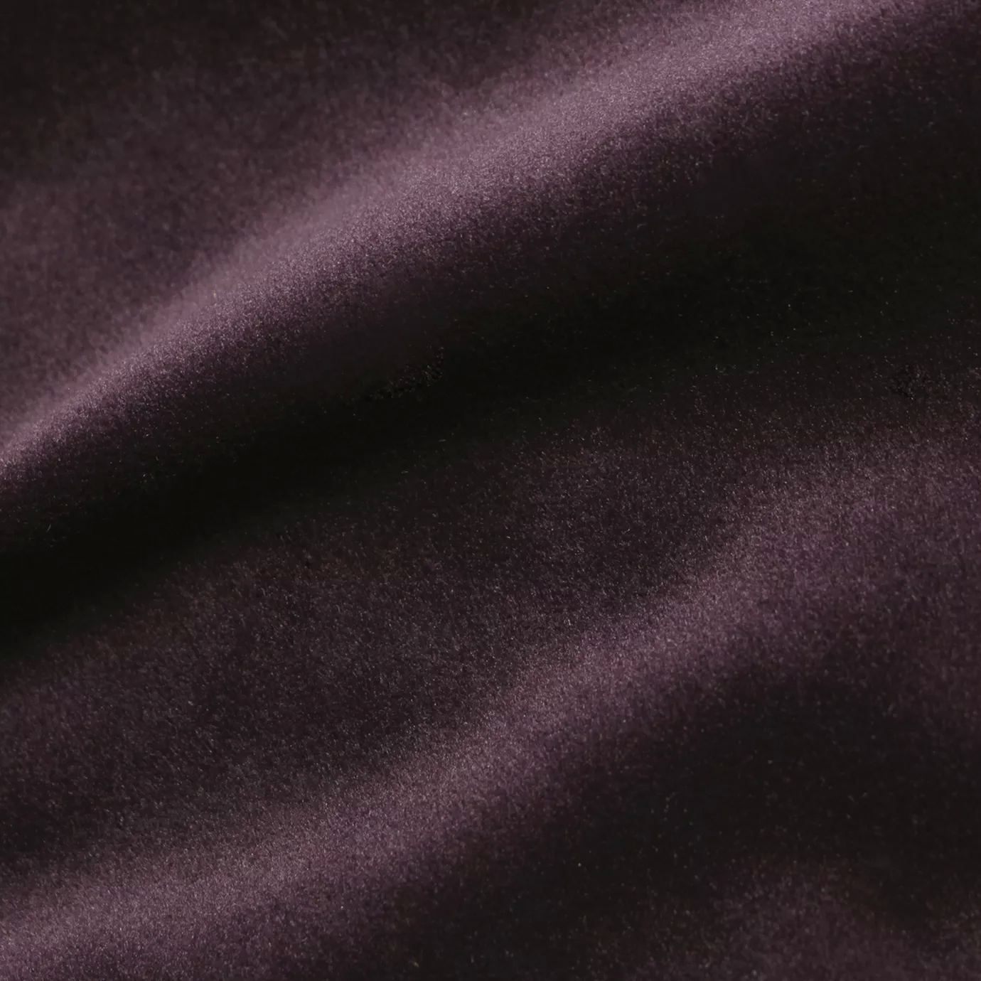 Elegant close-up of a Cozy Velvet Potent Purple fabric swatch in an intense and luxurious purple tone, showcasing its velvety texture and the gentle folds that give it a rich and vibrant depth.