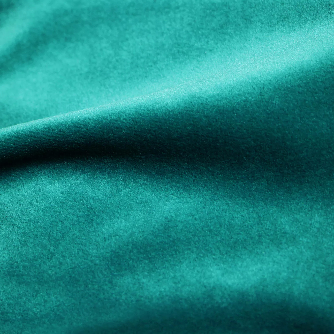 Elegant close-up of a Cozy Velvet Tropical Green fabric swatch in a vibrant and refreshing tropical green tone, showcasing its velvety texture and the gentle folds that give it a cheerful and inviting sheen.