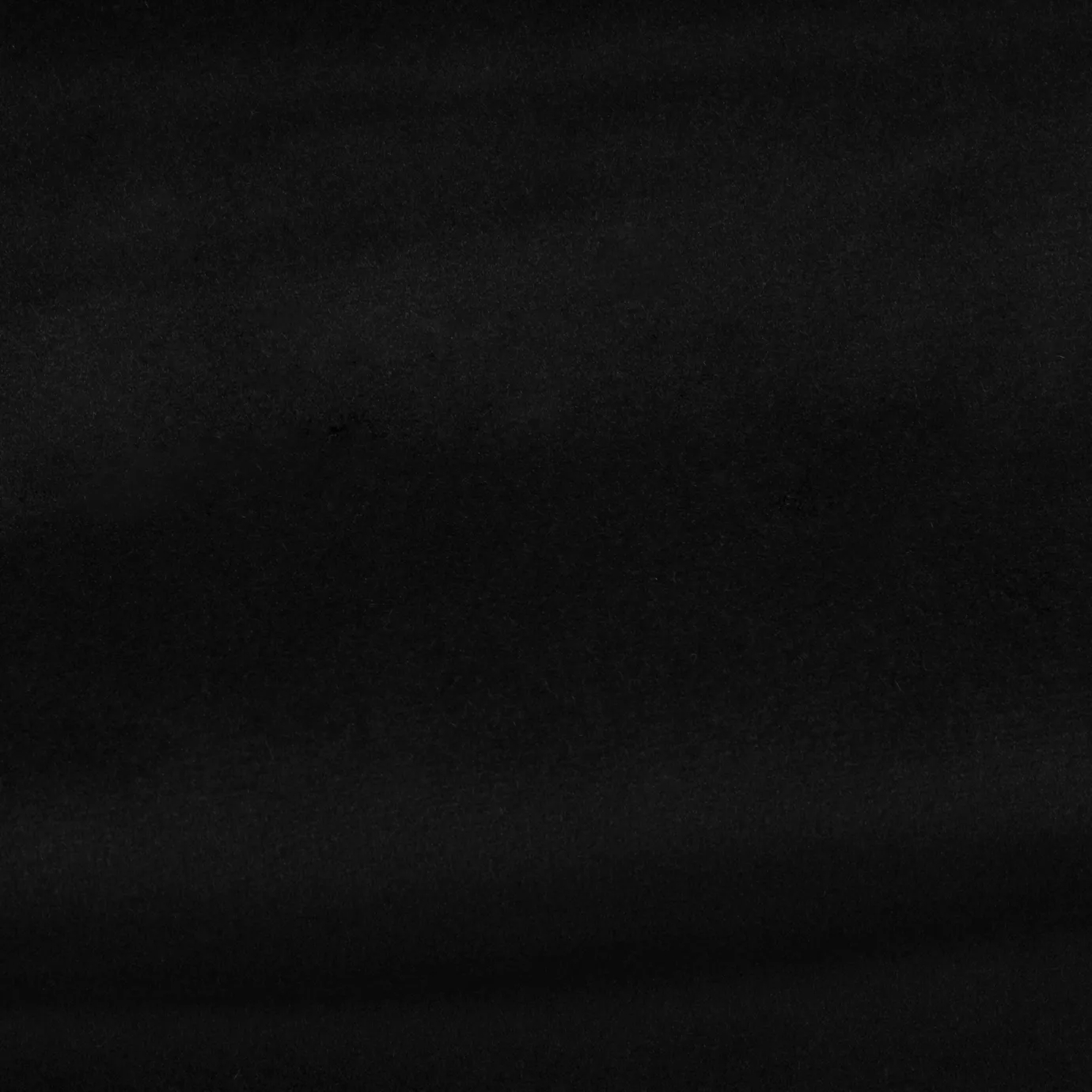Soft and elegant close-up of a Venice Velvet 29 fabric swatch in a deep and intense black tone, showcasing its velvety texture and a delicate sheen that gives it a feeling of comfort and timeless elegance.