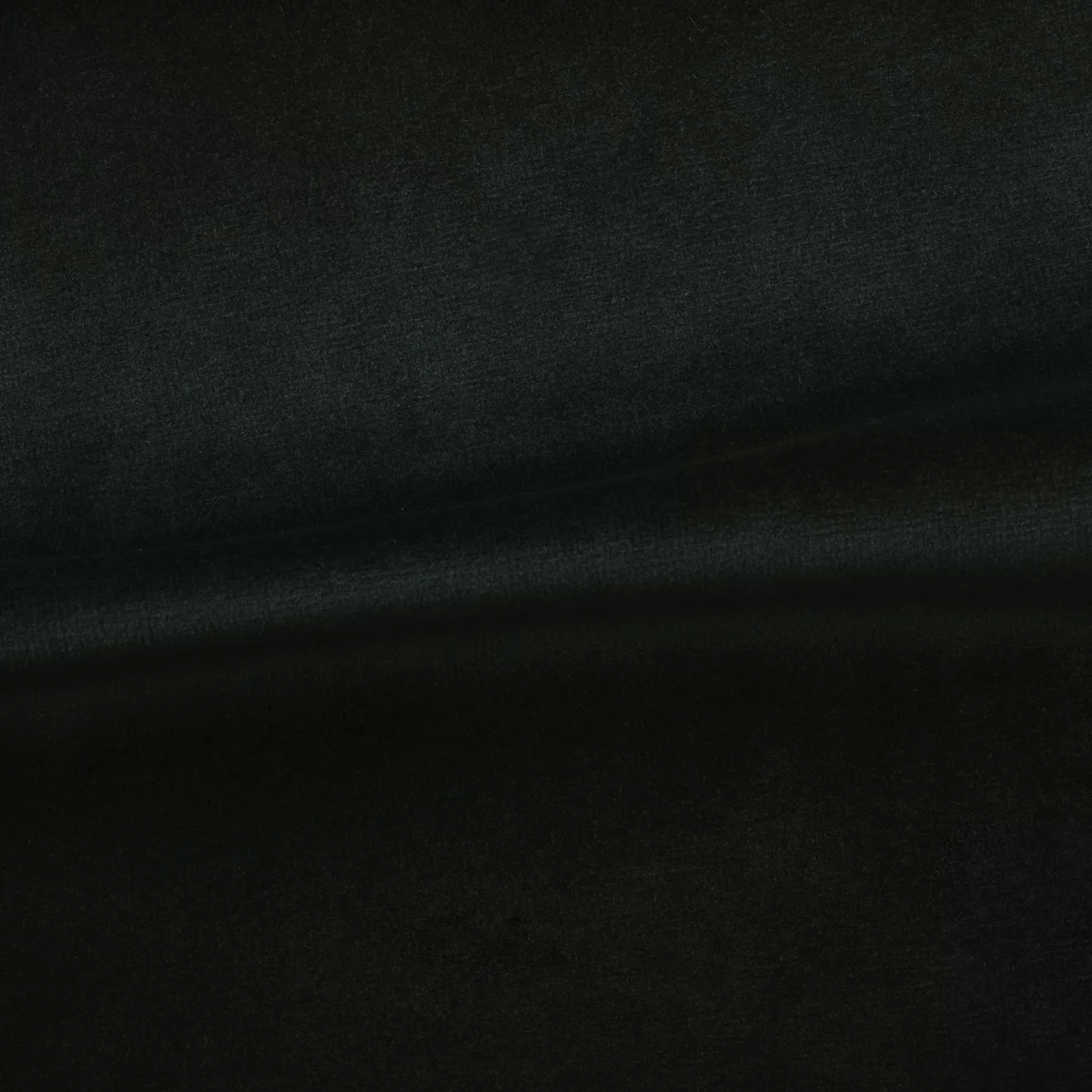 Soft and elegant close-up of a Venice Velvet 43 fabric swatch in a deep and sophisticated black tone, showcasing its velvety texture and a delicate sheen that gives it a feeling of comfort and timeless elegance.