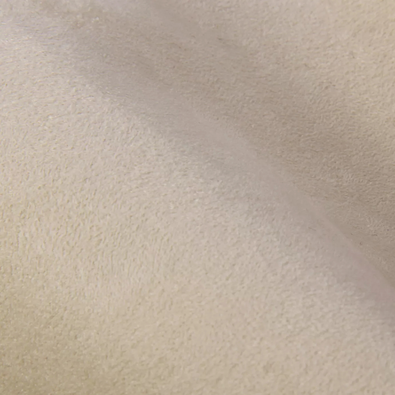 Soft close-up of an Ultra Suede Birch fabric swatch in a light and soft beige tone, showcasing its delicate texture and a gentle touch that gives it a feeling of comfort and natural elegance.