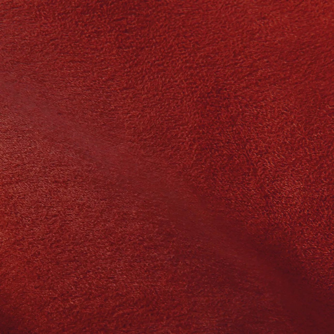 Soft close-up of an Ultra Suede Poinsettia fabric swatch in a vibrant and warm red tone, showcasing its delicate texture and a gentle touch that gives it a feeling of comfort and natural elegance.