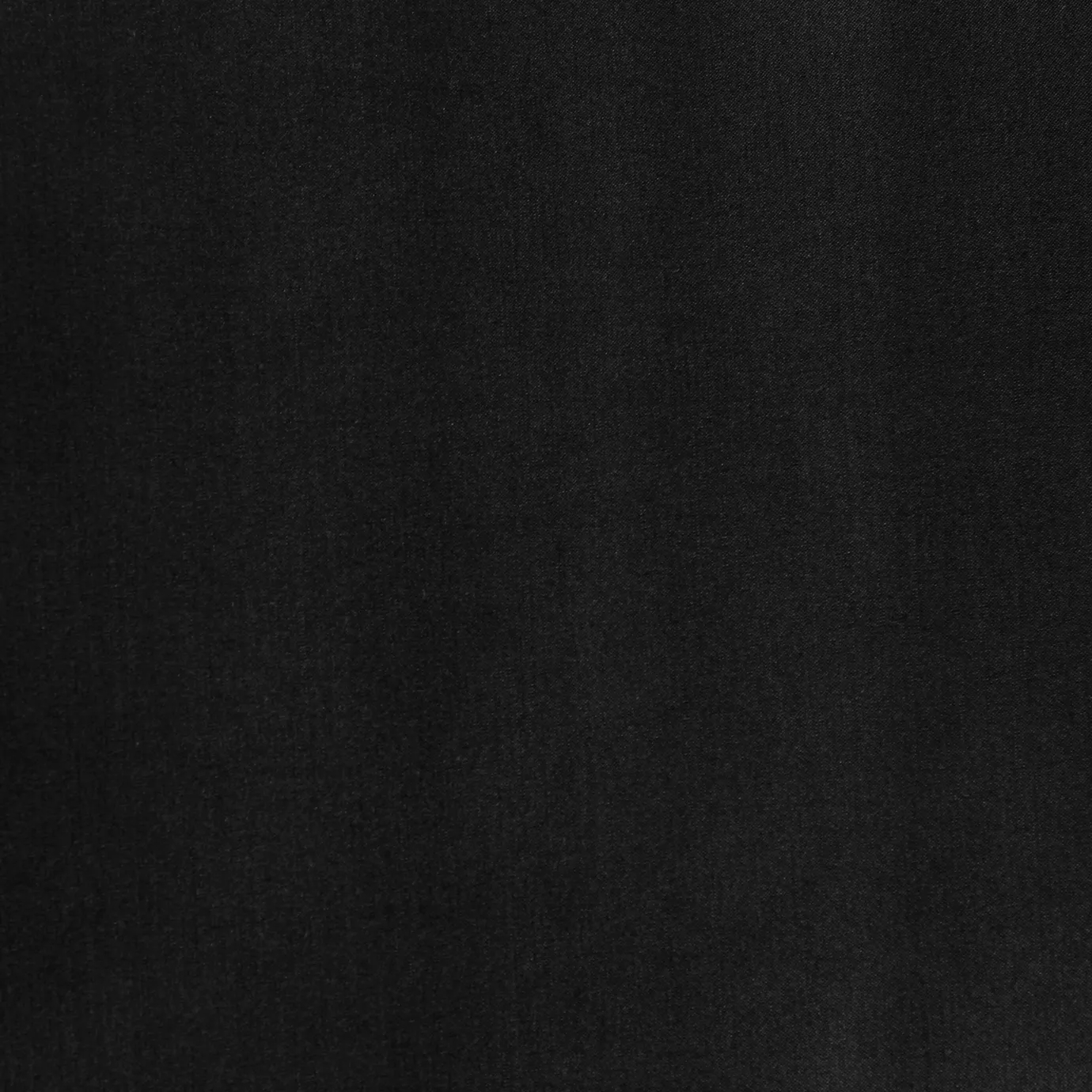Soft close-up of a Satina Lux Black fabric swatch in a deep and elegant black tone, showcasing its smooth texture and a subtle sheen that gives it a feeling of sophistication and timelessness.