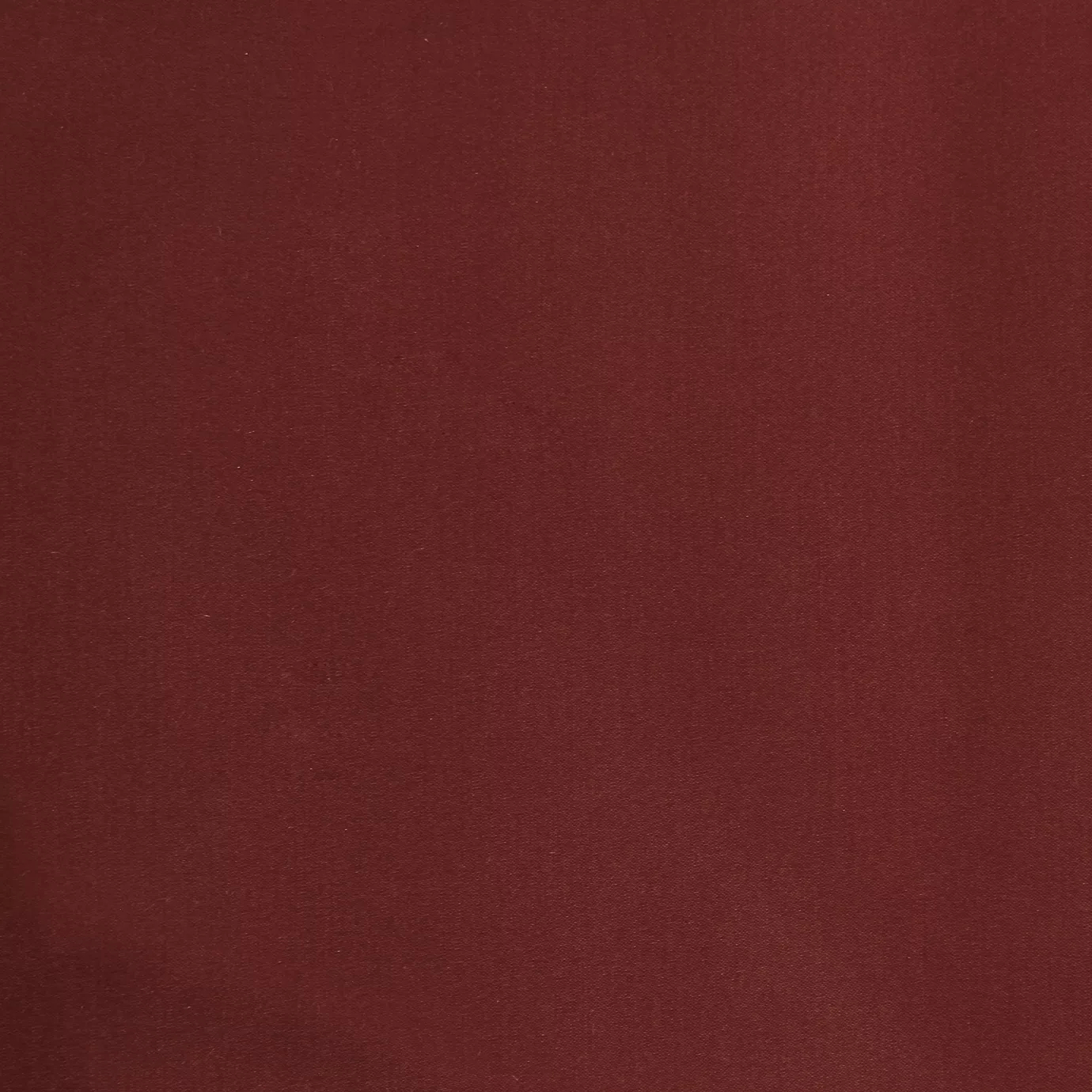 Soft close-up of a Satina Lux Cherry Red fabric swatch in a rich and elegant cherry red tone, showcasing its smooth texture and a subtle sheen that gives it a feeling of sophistication and warmth.