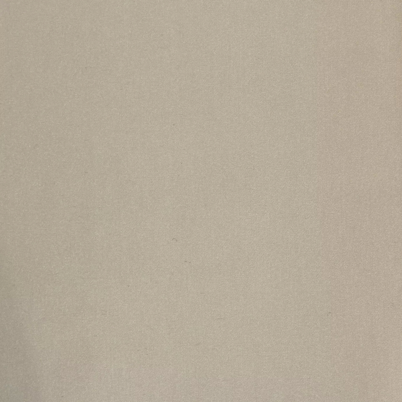 Soft close-up of a Satina Lux Cloud Dancer fabric swatch in a light and ethereal beige tone, showcasing its smooth texture and a subtle sheen that gives it a feeling of sophistication and lightness.