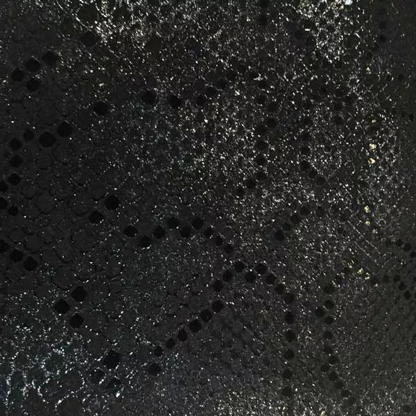 Elegant close-up of a Bitis Jet Black leather swatch with an exotic pattern mimicking snake skin in an intense black tone with subtle shimmers, featuring a slightly rough texture with distinct scales, evoking a feeling of mystery and bold sophistication.