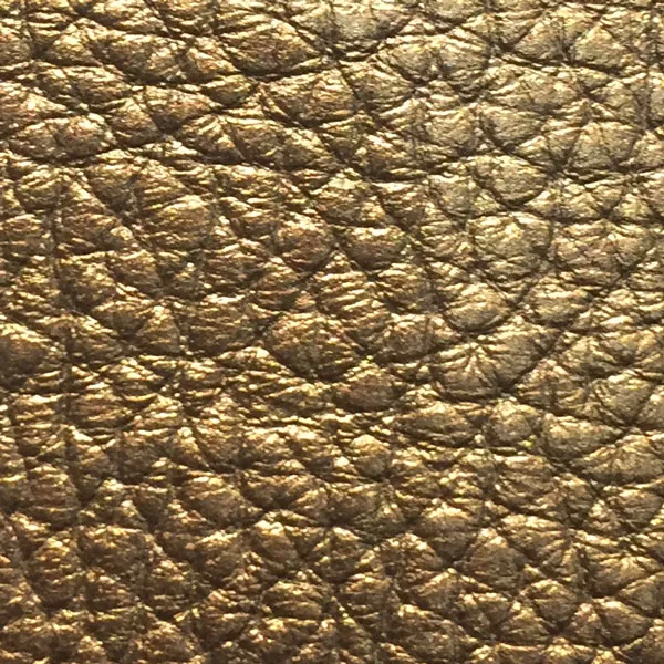 Close-up of a Harbor Gold fabric swatch in a textured, bright gold tone, showcasing its raised areas and grooves that give it a luxurious and elegant feel. The intense sheen highlights the depth of its texture.