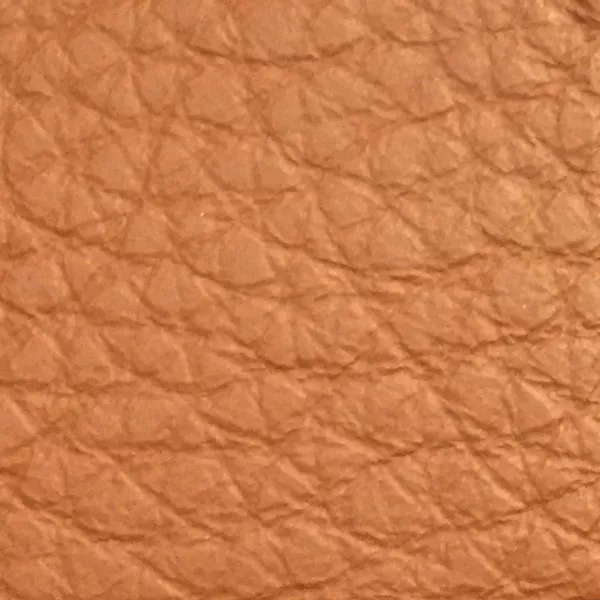 Close-up of a Harbor Mocha Bisque fabric swatch in a light brown tone with texture, showcasing its raised areas and grooves that give it a natural and elegant feel. The soft sheen highlights the depth of its texture.