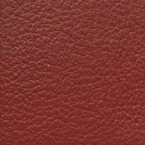 Close-up of a Harbor Red Ochre fabric swatch in a warm red ochre tone with texture, showcasing its raised areas and grooves that give it a natural and elegant feel. The soft sheen highlights the depth of its texture.