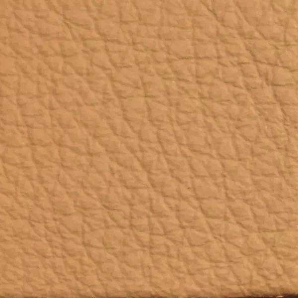 Close-up of a Harbor Sandstorm fabric swatch in a light sandy beige tone with texture, showcasing its raised areas and grooves that give it a natural and elegant feel. The soft sheen highlights the depth of its texture.