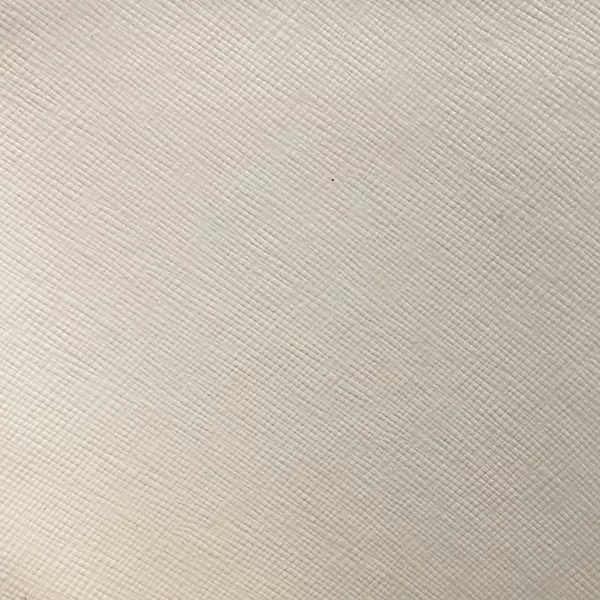 A detailed view of Nomad Synthetic Leather in a very light, almost white tone shows a fine, diagonal cross-hatch texture.