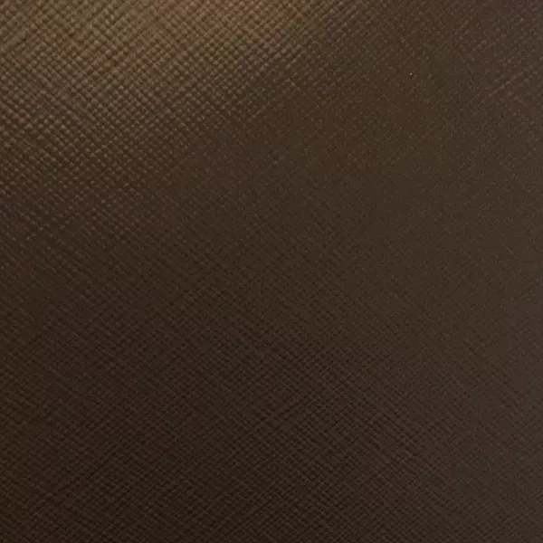 A close-up of Nomad Synthetic Leather shows a finely textured surface with a subtle, diagonal cross-hatch pattern in a rich, dark brown.