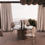 Outdoors Dining Al Fresco space, with teo elegant chairs in cream tones and a glass table.