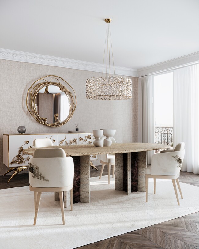 A dining room with a large marble oval dining table in the center, surrounded by four dining chairs in neutral hues. Behind the table and chairs, there is a white and golden cabinet with floral motifs, and a mirror above it.