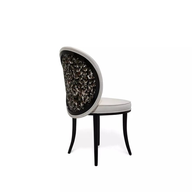 Merveille Folie Feather Back Dining Chair: featuring a neutral colored strucuture, with a black frame and cream upholstery, this chair stands out for its feather adorned backrest.