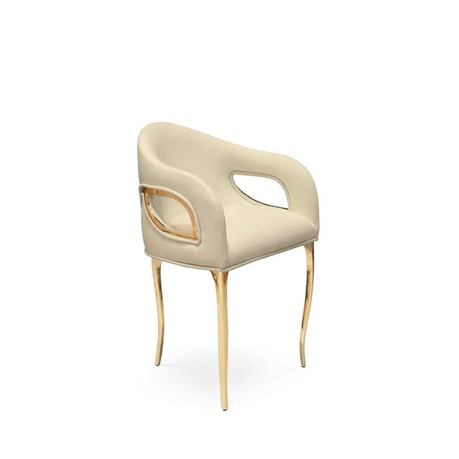 Display of Chandra Dining Chair, demonstrating its distinctive feature of only having 3 legs, its frame combining with the elegant cream upholstery.