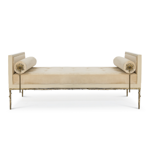 A cream upholestry daybed with golden structure and floral-themed details.