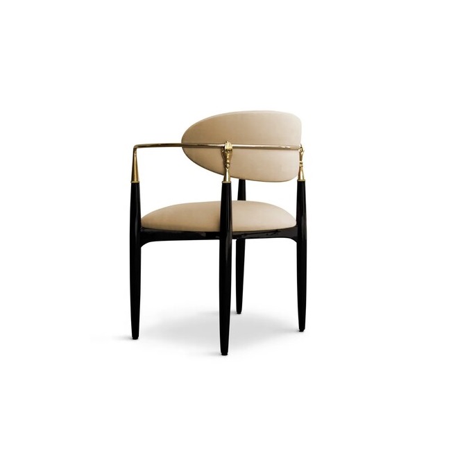Nahéma Chair: contrasting with its black structure, the chair has velvet upholstery in cream tones, with luxurious golden details.
