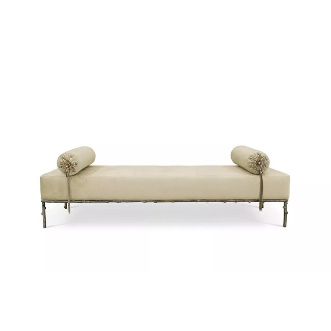 A cream upholestry bench with golden structure and floral-themed details.