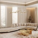 A neutral colored room with a large Heavenly Sofa in the center. The room also features some golden details such as the chandelier above it and the Myth Coffee Table next to the sofa.