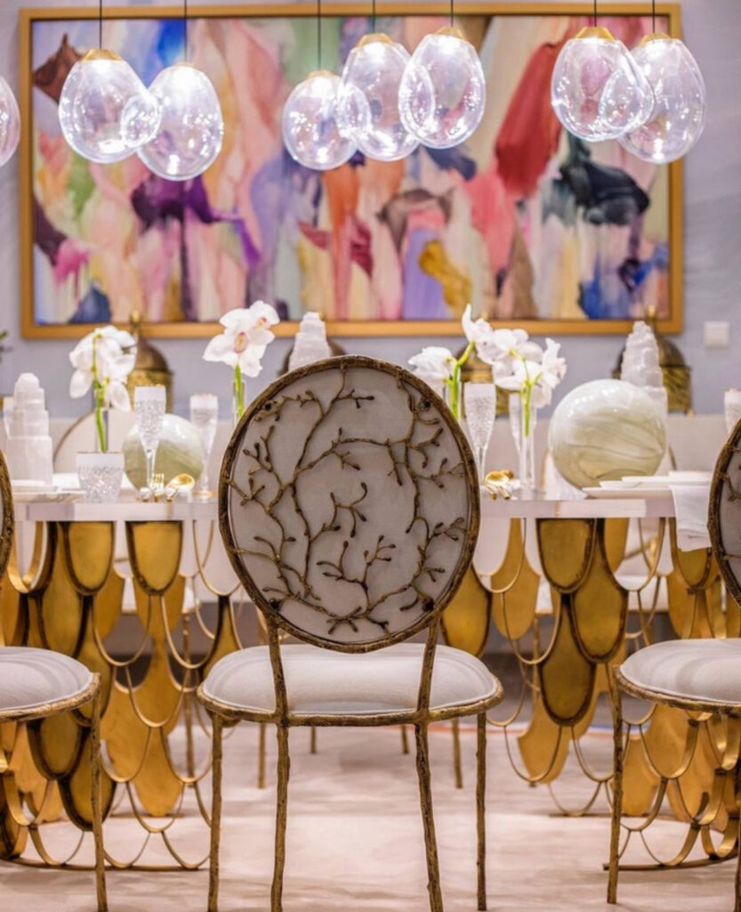 luxury nature inspired interior design with gold and white dining chairs with branch detailing