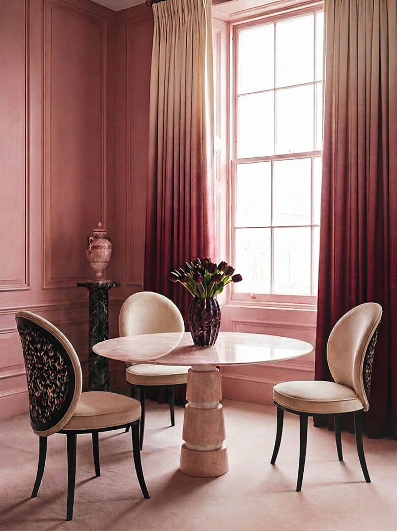 Round marble dining table with sculptural chairs in a cinematic, blush-toned interior by KOKET