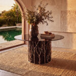 The Story Behind the Design: Enchanted the story behind the enchanted collection by koket - enchanted branch metal handmade table in a beautiful stone foyer setting with a pool in the background